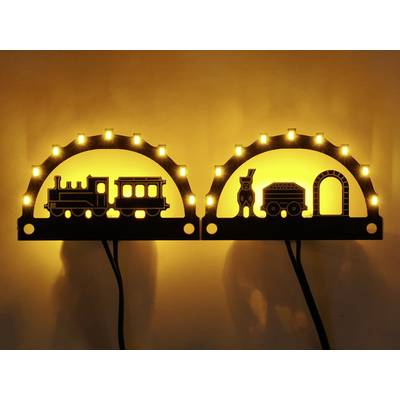 Une lampe murale décorative représentant des silhouettes d'un train et d'un tunnel, illuminée par une lumière jaune chaleureuse.
