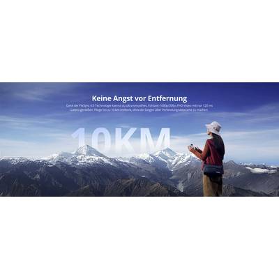 « Une personne portant un chapeau contrôle un drone, debout sur un sommet de montagne. Le texte en allemand indique : « Keine Angst vor Entfernung », soulignant la capacité de longue portée. »