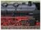 Un gros plan du côté d'une locomotive à vapeur vintage, mettant en valeur ses composants mécaniques complexes et ses couleurs vives rouge et noir.