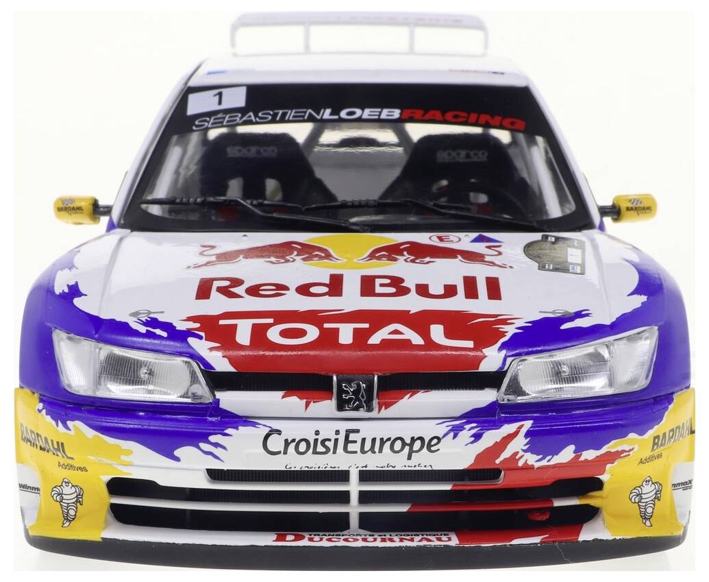 Une voiture de rallye miniature avec un marquage Red Bull et Total aux couleurs vives sur sa carrosserie. La banderole sur le pare-brise indique Sébastien Loeb Racing.