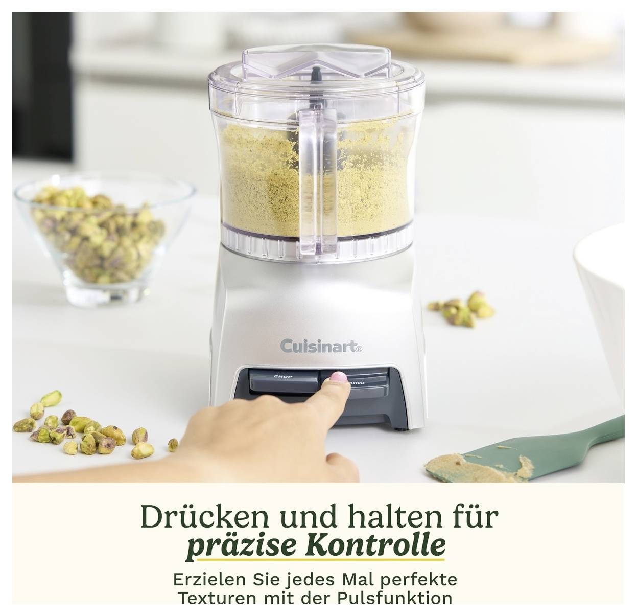 Une personne appuie sur le bouton d'un hachoir de cuisine pour broyer des noix. Texte sur l'image : 'Appuyer et maintenir pour un contrôle précis'.