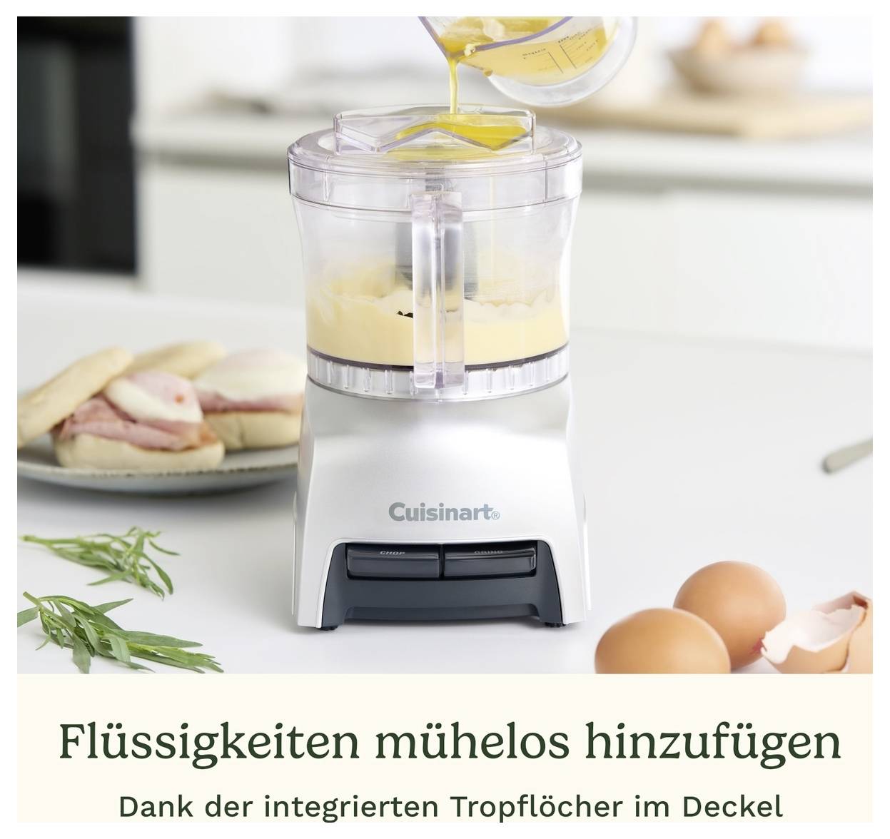 Robot de cuisine préparant un mélange de crème. Le liquide est ajouté par le couvercle. Texte en dessous : « Ajouter des liquides sans effort ».