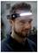 Un homme portant un lampadaire frontal qui émet une lumière blanche vive, indiquant qu'il est conçu pour un éclairage sans les mains dans un environnement sombre.