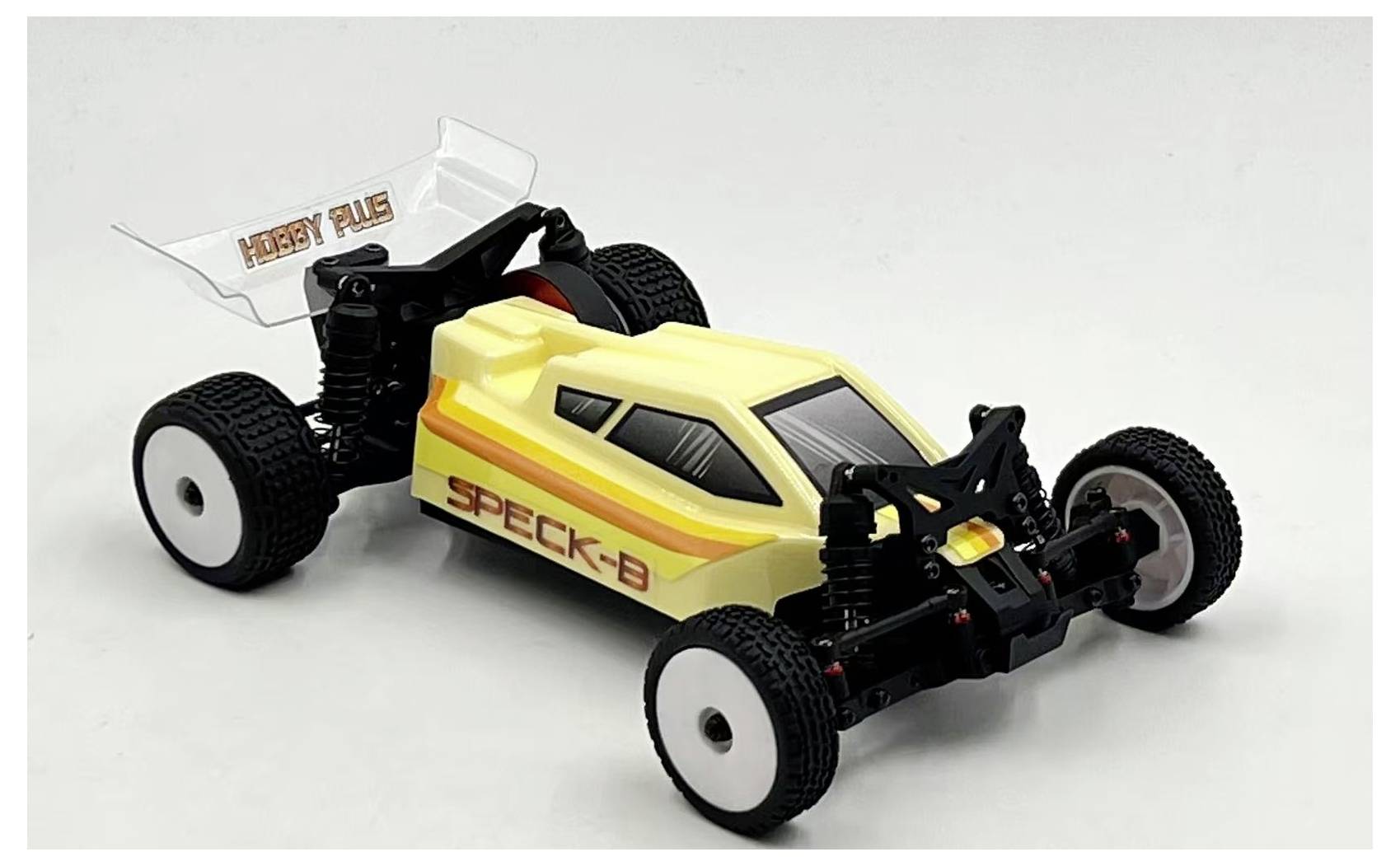 Une voiture de course télécommandée jaune et blanche avec des roues noires et des détails de bande rouge, étiquetée 'SPECK-B' et 'HOBBY PLUS' sur le spoiler.