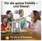 Une famille avec deux enfants sourit en mangeant une fondue. Au premier plan se trouvent un appareil à fondue électrique et des couverts.