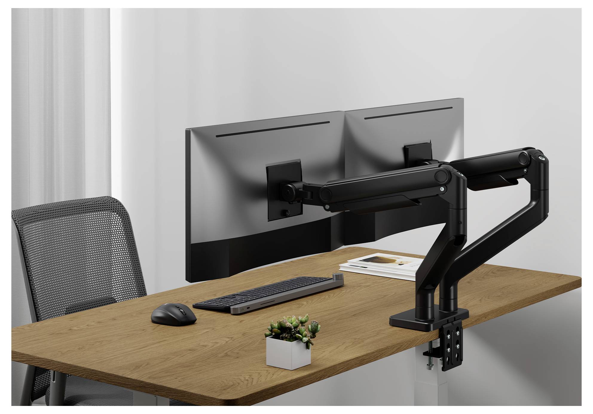 Configuration à double écran sur un bureau en bois avec clavier, souris et petite plante en pot, sur un fond gris clair.