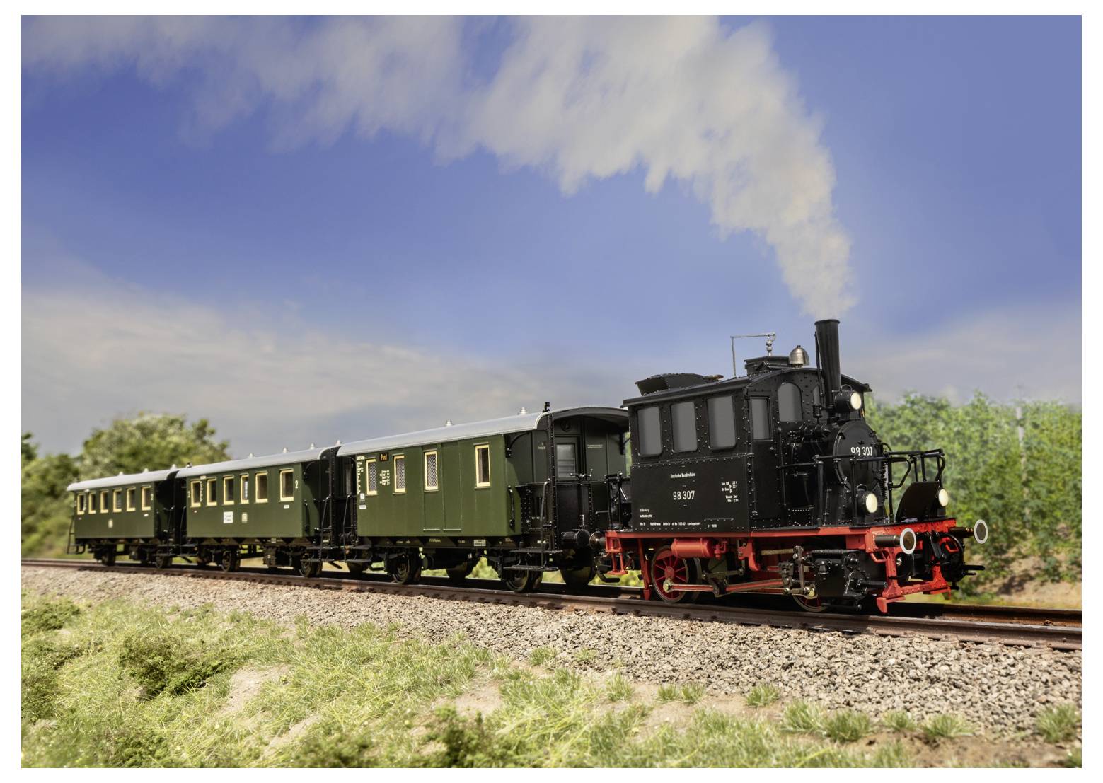 Une locomotive à vapeur noire vintage tire deux voitures de passagers vertes le long d'une voie ferrée rurale sous un ciel bleu parsemé de nuages.