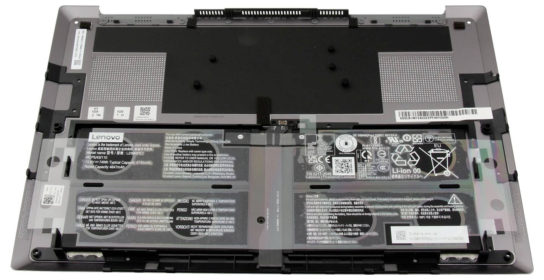 Ouverture de la face arrière d'un ordinateur portable Lenovo, révélant les composants internes, comprenant la batterie, la zone du ventilateur de refroidissement, et divers connecteurs et étiquettes.