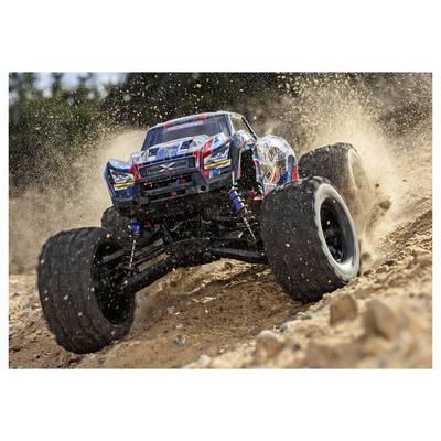 Un monster truck télécommandé traversant un circuit de terre, soulevant de la poussière et des débris tandis qu'il accélère sur un terrain rocailleux.