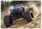 Un monster truck télécommandé traversant un circuit de terre, soulevant de la poussière et des débris tandis qu'il accélère sur un terrain rocailleux.