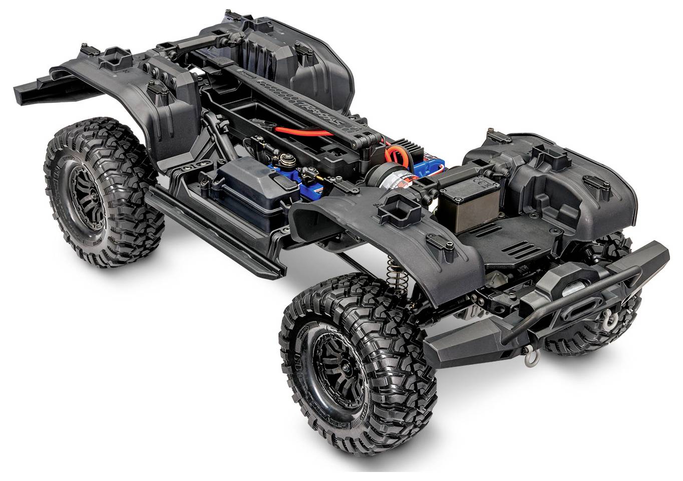Châssis de camion tout-terrain RC avec composants internes exposés, comprenant de grandes roues, un pack de batterie et un système de suspension.