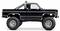 Un pick-up tout-terrain surélevé noir avec de grandes roues et des détails chromés. Il dispose d'une suspension surélevée et de tuyaux d'échappement apparents.
