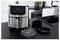 Un appareil de friture sans huile en acier inoxydable posé sur un plan de travail de cuisine, avec un affichage numérique indiquant 180°C et 15:00. À proximité se trouvent des accessoires de cuisine.