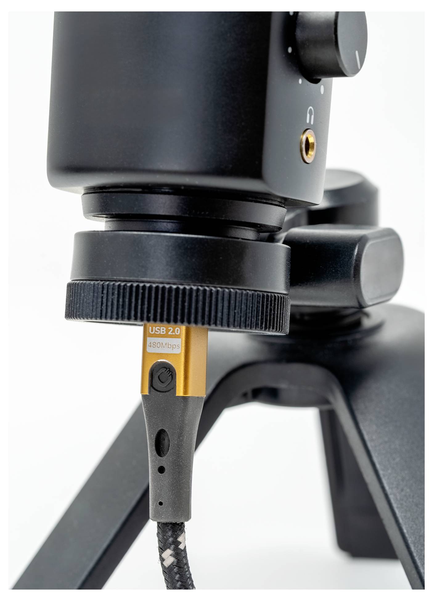 « Un périphérique USB 2.0 connecté au support d'un microphone noir, indiquant une configuration pour l'enregistrement audio ou le streaming. »