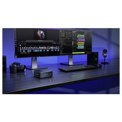 Un setup de bureau moderne avec deux moniteurs affichant des logiciels de montage vidéo et audio, un appareil photo, un microphone, un clavier et un petit ordinateur de bureau.