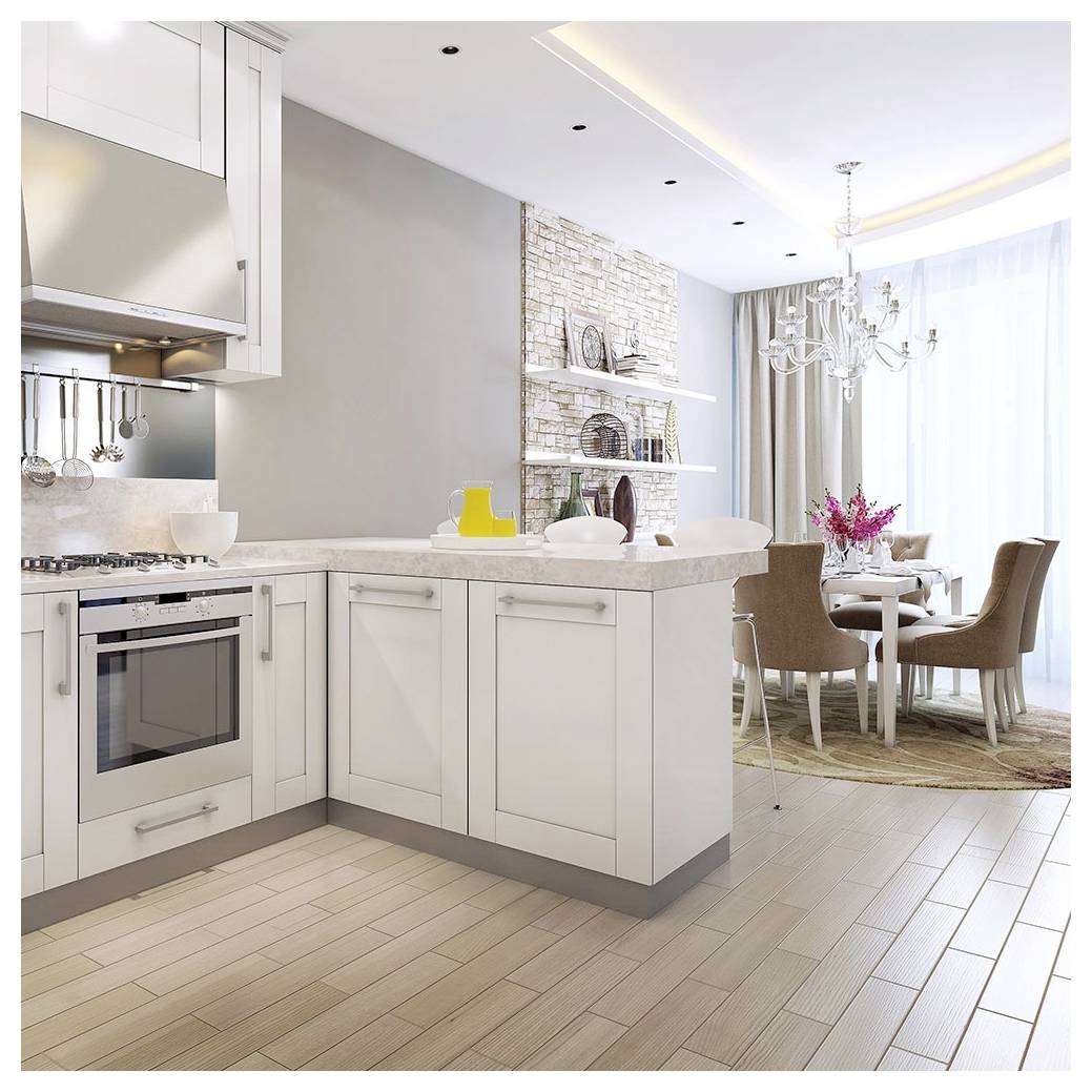 Une cuisine moderne avec des armoires blanches et des plans de travail beiges s'ouvre sur un espace repas avec une table dressée pour quatre personnes. Un lustre est suspendu au-dessus de la table.