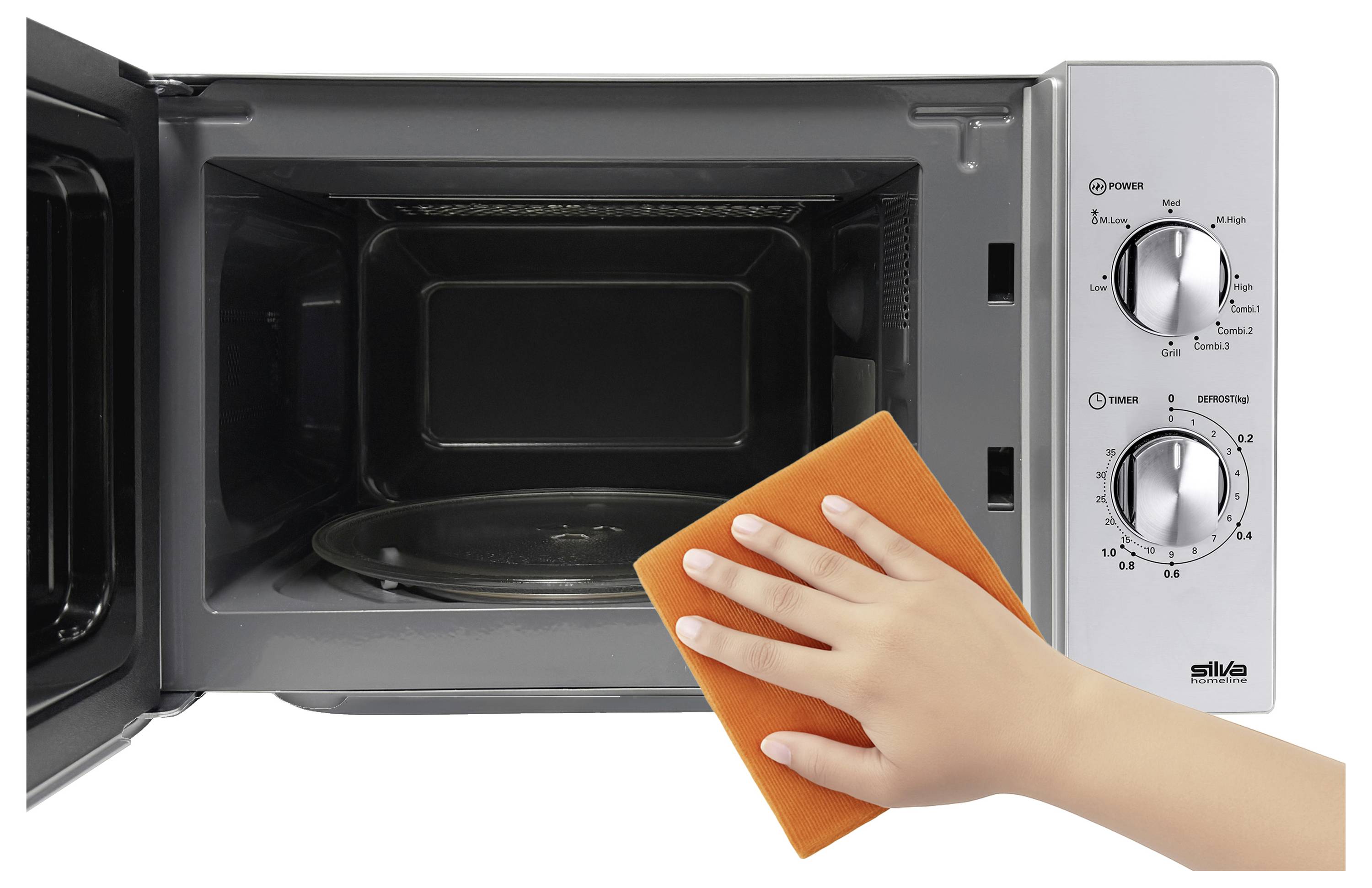 Un four à micro-ondes ouvert avec une main tenant une éponge orange, suggérant un nettoyage ou une maintenance. Les boutons de puissance, de minuterie et de décongélation sont visibles.