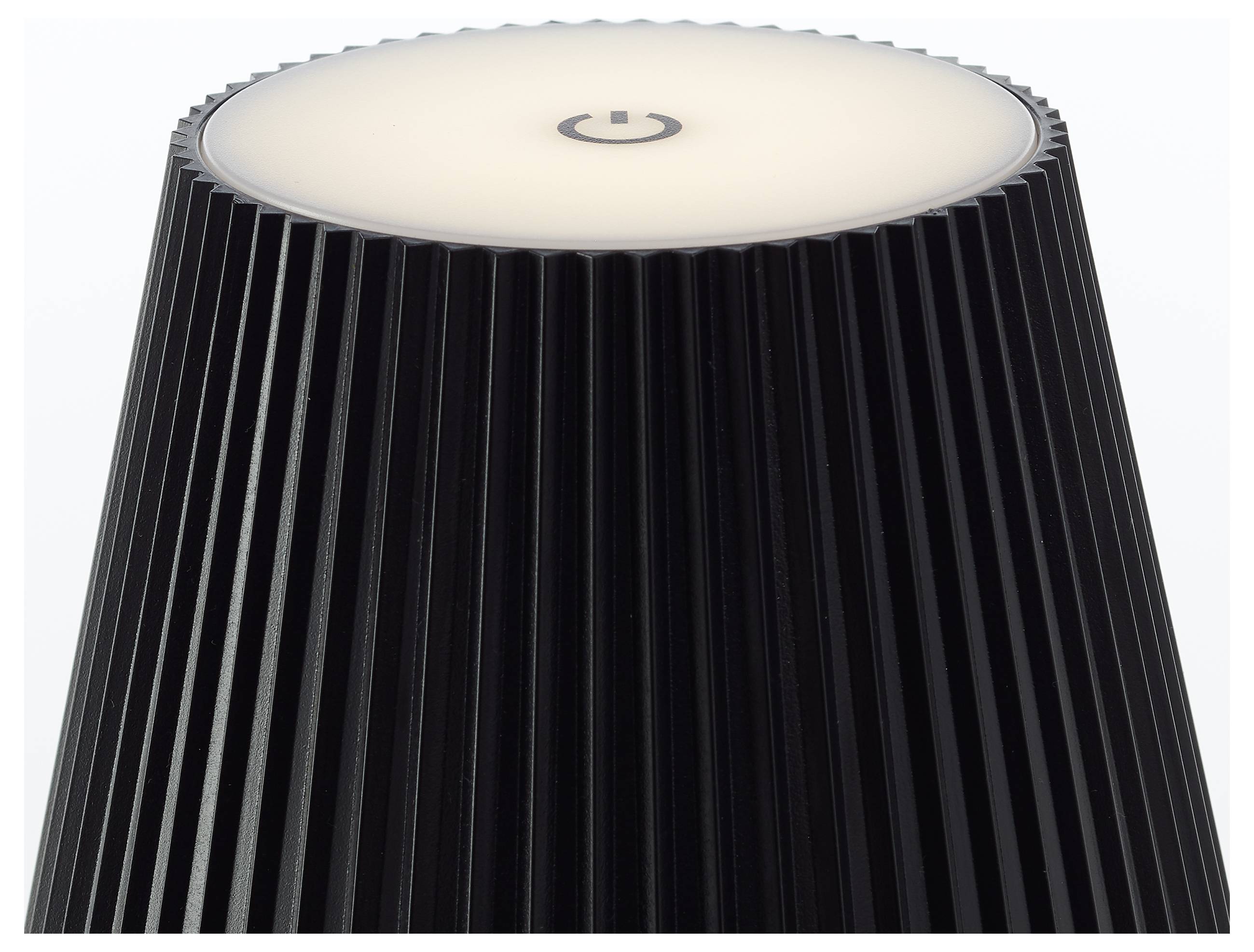 Un dispositif cylindrique noir avec des rainures verticales et un sommet lumineux présentant un symbole de mise en marche.