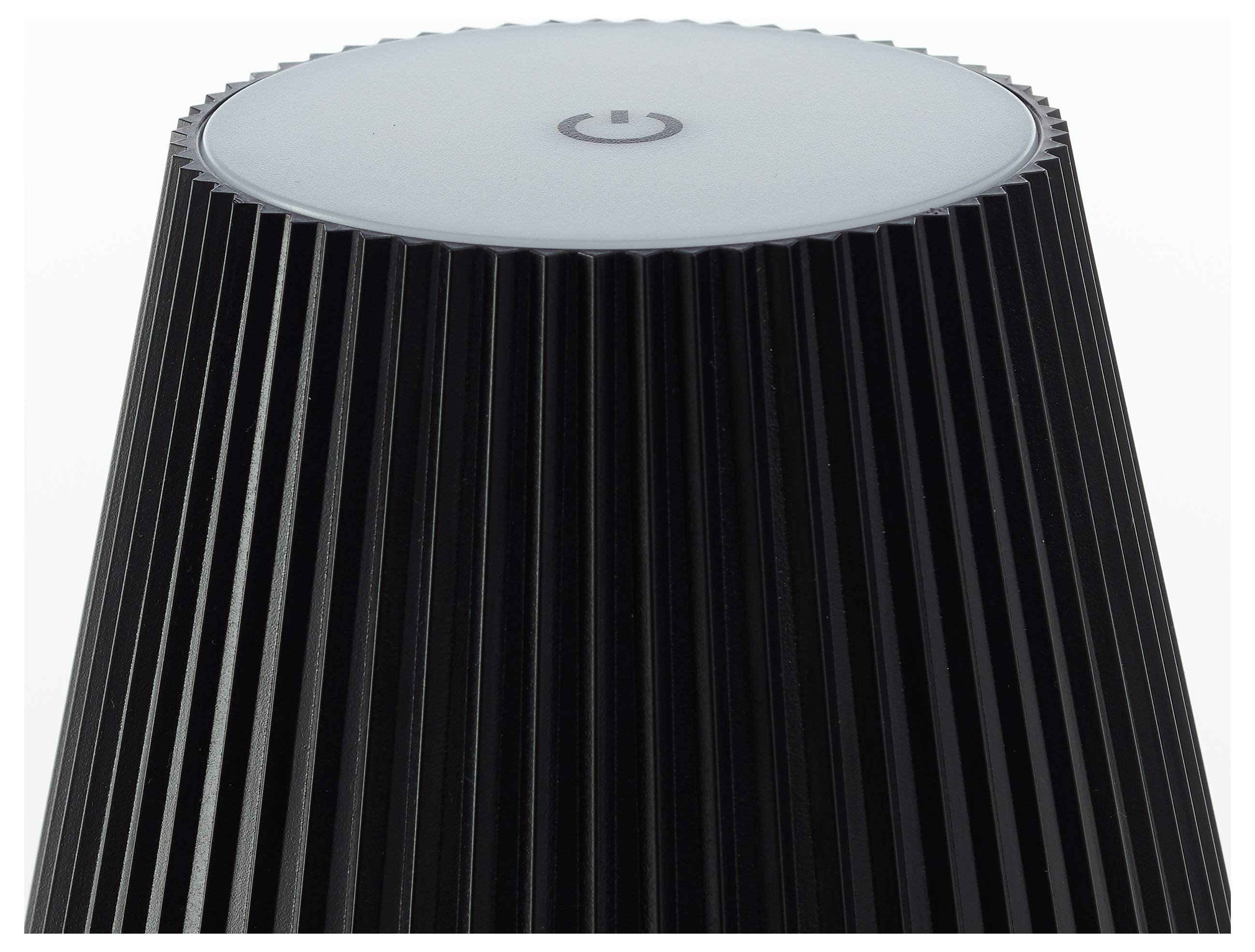 Un haut-parleur intelligent sombre aux côtes nervurées, arborant un symbole de mise en marche sur son sommet, suggérant qu'il est éteint ou en attente d'activation.