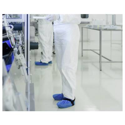Une personne vêtue d'une combinaison de salle blanche et de couvre-chaussures bleus utilise un équipement, suggérant un environnement de laboratoire contrôlé.