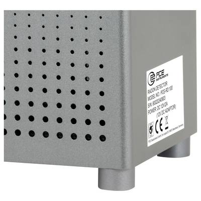Appareil de détection du radon PCE gris avec évents latéraux perforés et étiquette du produit sur le panneau avant droit.