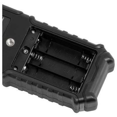 Gros plan d'un compartiment de batterie noir vide avec deux contacts ressort et des bornes métalliques sur un appareil portatif.
