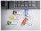 Cinq clés USB étiquetées « Événements », « Vacances 2025 », « Documents », « Sauvegarde » et « Impôts » sont placées près d'un clavier d'ordinateur portable.