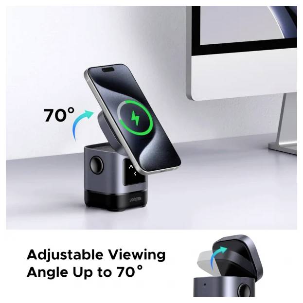 Un téléphone intelligent se chargeant sur un socle noir avec un angle réglable jusqu'à 70 degrés à côté d'un moniteur d'ordinateur.