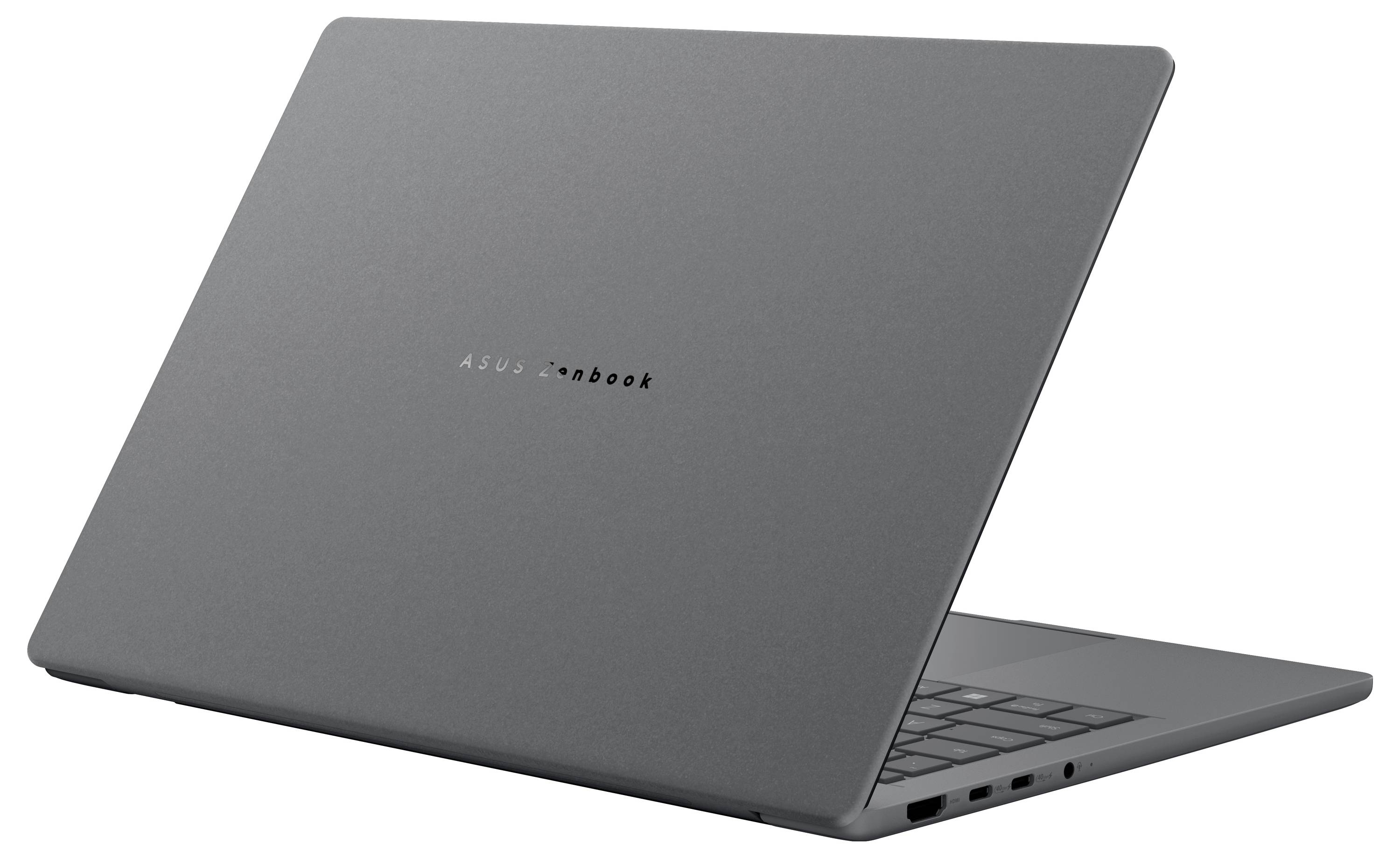 Un élégant ordinateur portable fermé au design minimaliste gris, montrant la forme compacte de l'appareil et son profil léger, vu sous un angle.