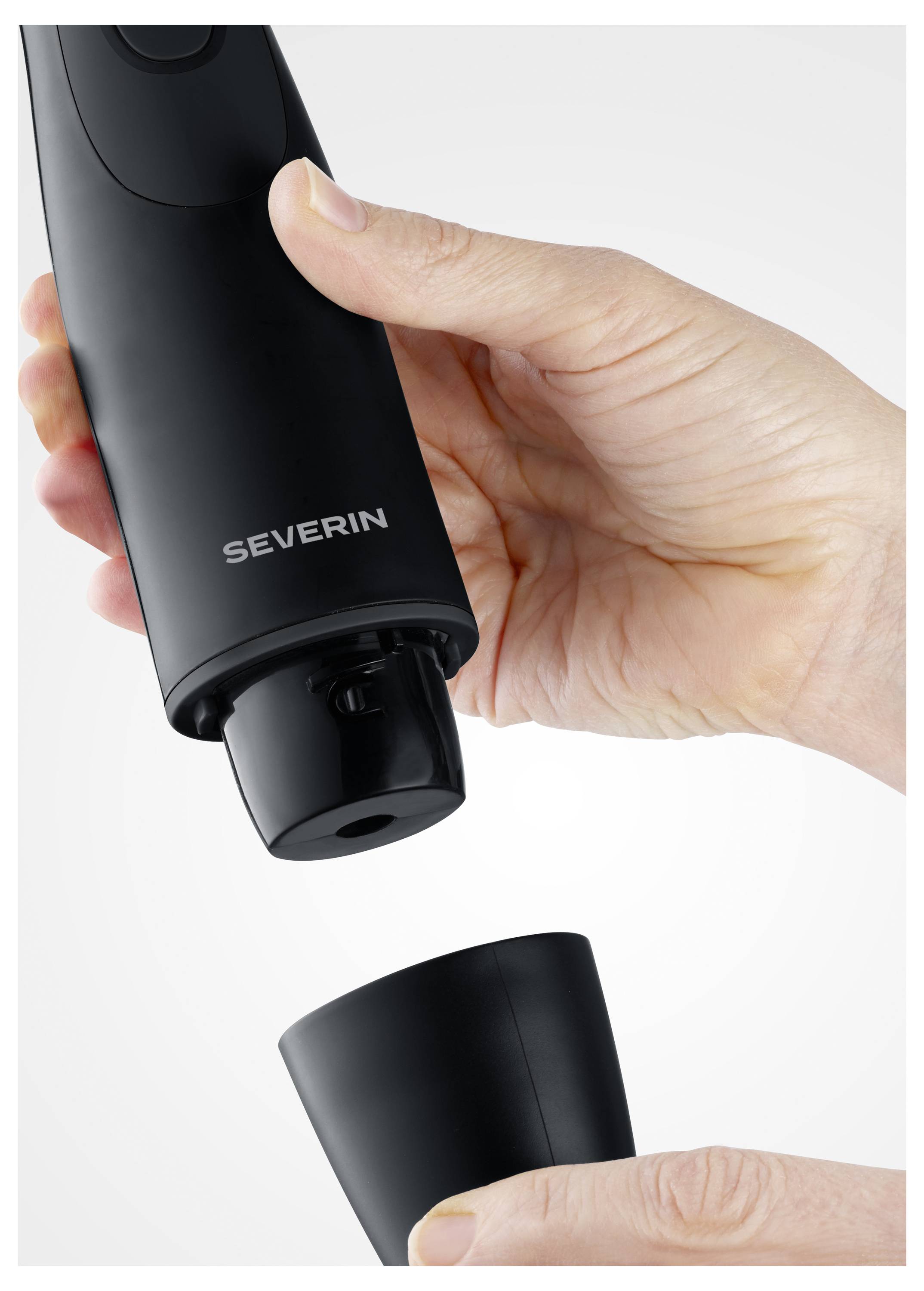 Deux mains tiennent un tire-bouchon électrique noir de marque « SEVERIN ». Une main saisit l'appareil principal, et l'autre retire le capuchon inférieur.
