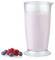 Un grand verre de smoothie aux baies roses à côté d'un bouquet de myrtilles et framboises fraîches.