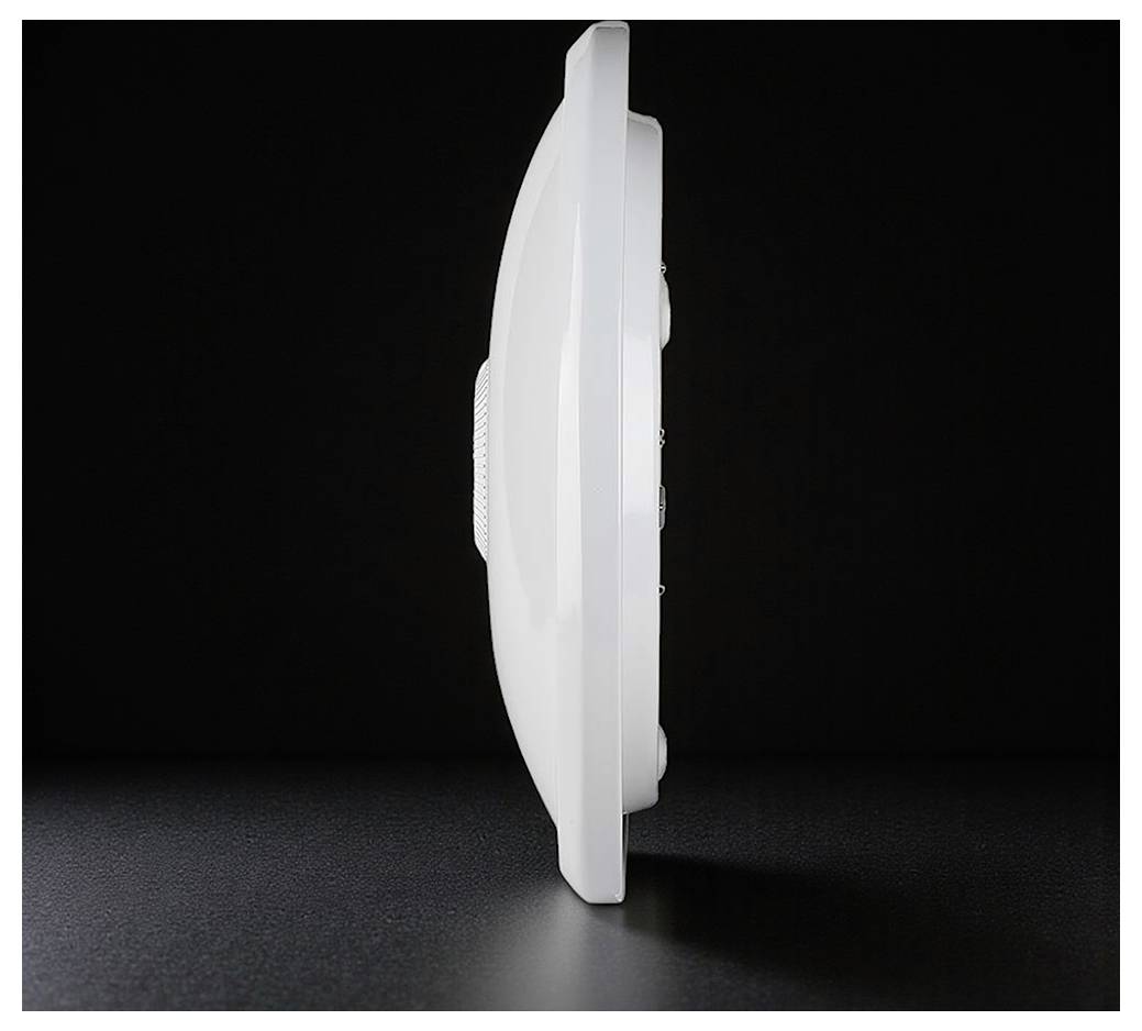 Vue latérale d'un détecteur de fumée blanc circulaire sur un fond sombre.