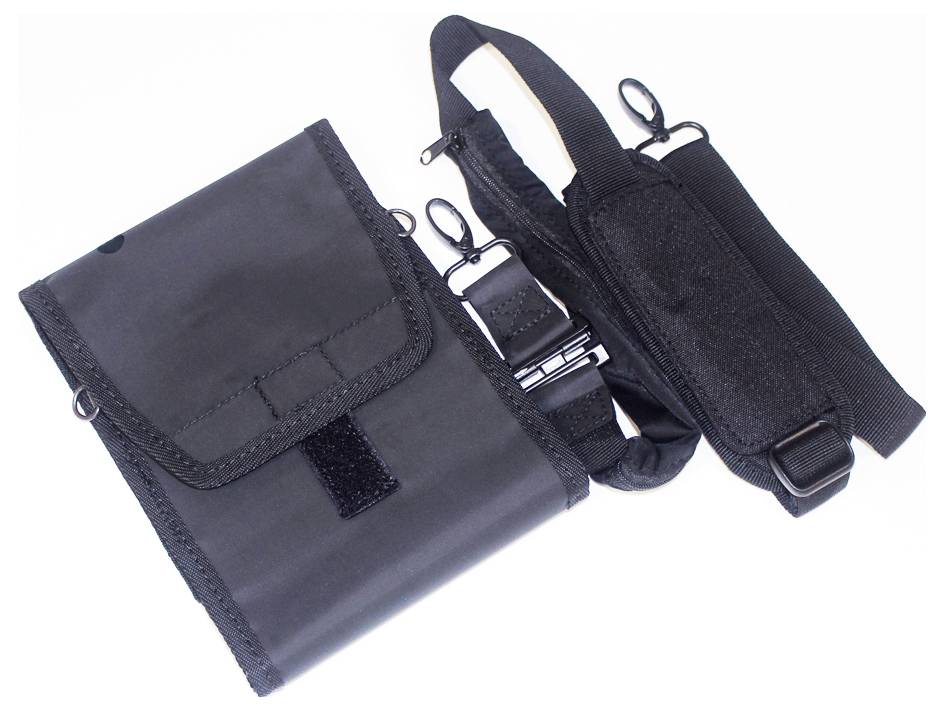 Pochette en tissu noir avec rabat Velcro et sangle réglable dotée de pinces métalliques et de boucles en plastique, présentée ouverte.