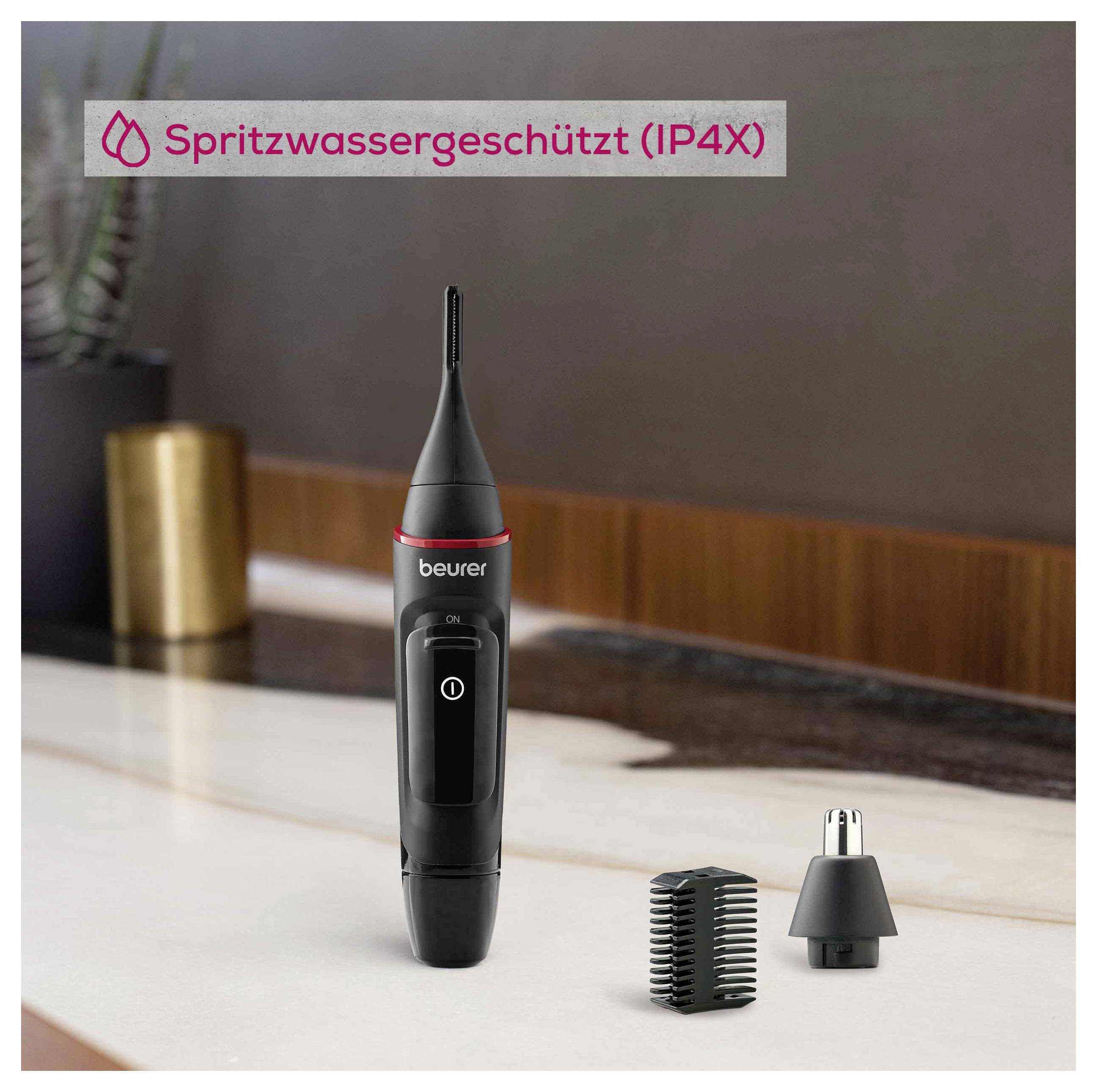 Tondeuse à nez et oreilles sur un comptoir de salle de bains avec des accessoires à proximité. Le texte indique qu'elle est résistante aux éclaboussures (IP4X).