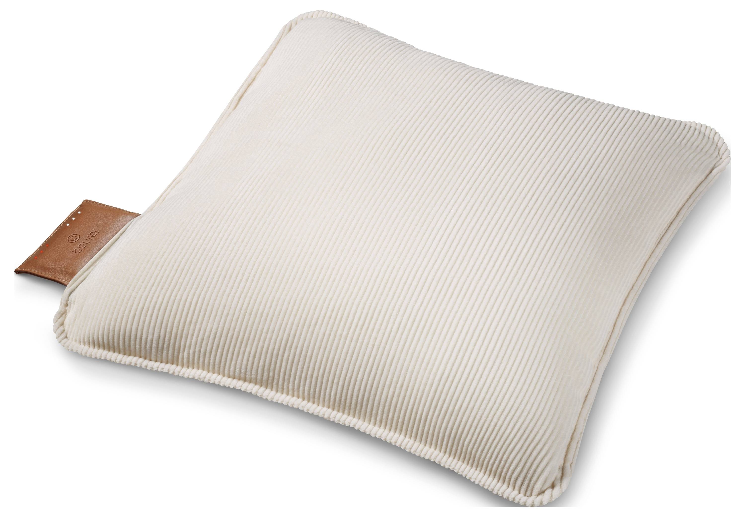 Un coussin carré beige avec une texture de velours côtelé et une étiquette en cuir marron sur un côté, reposant sur un fond blanc.
