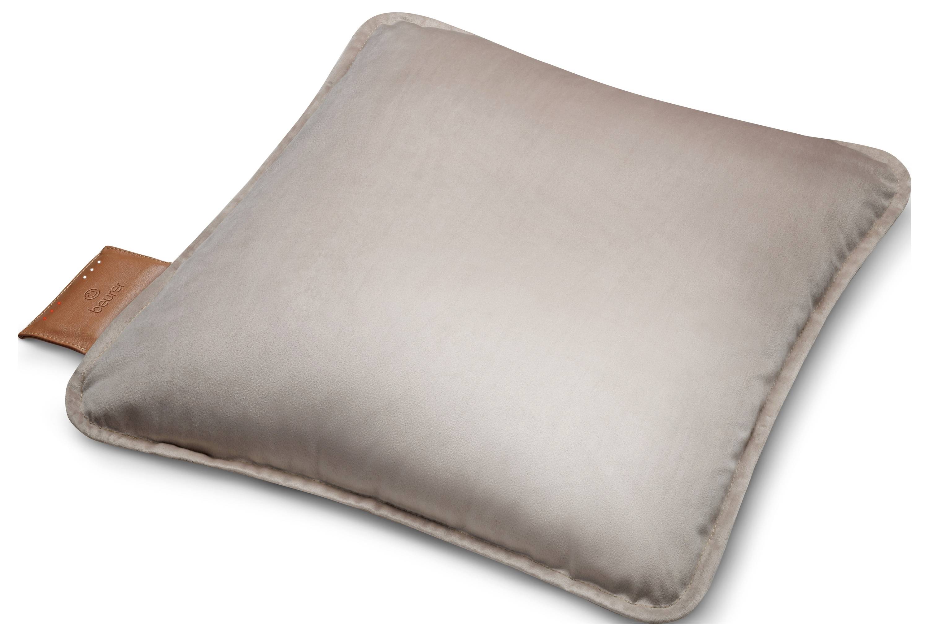Un coussin carré en cuir beige avec une étiquette en cuir sur un bord repose sur une surface blanche.