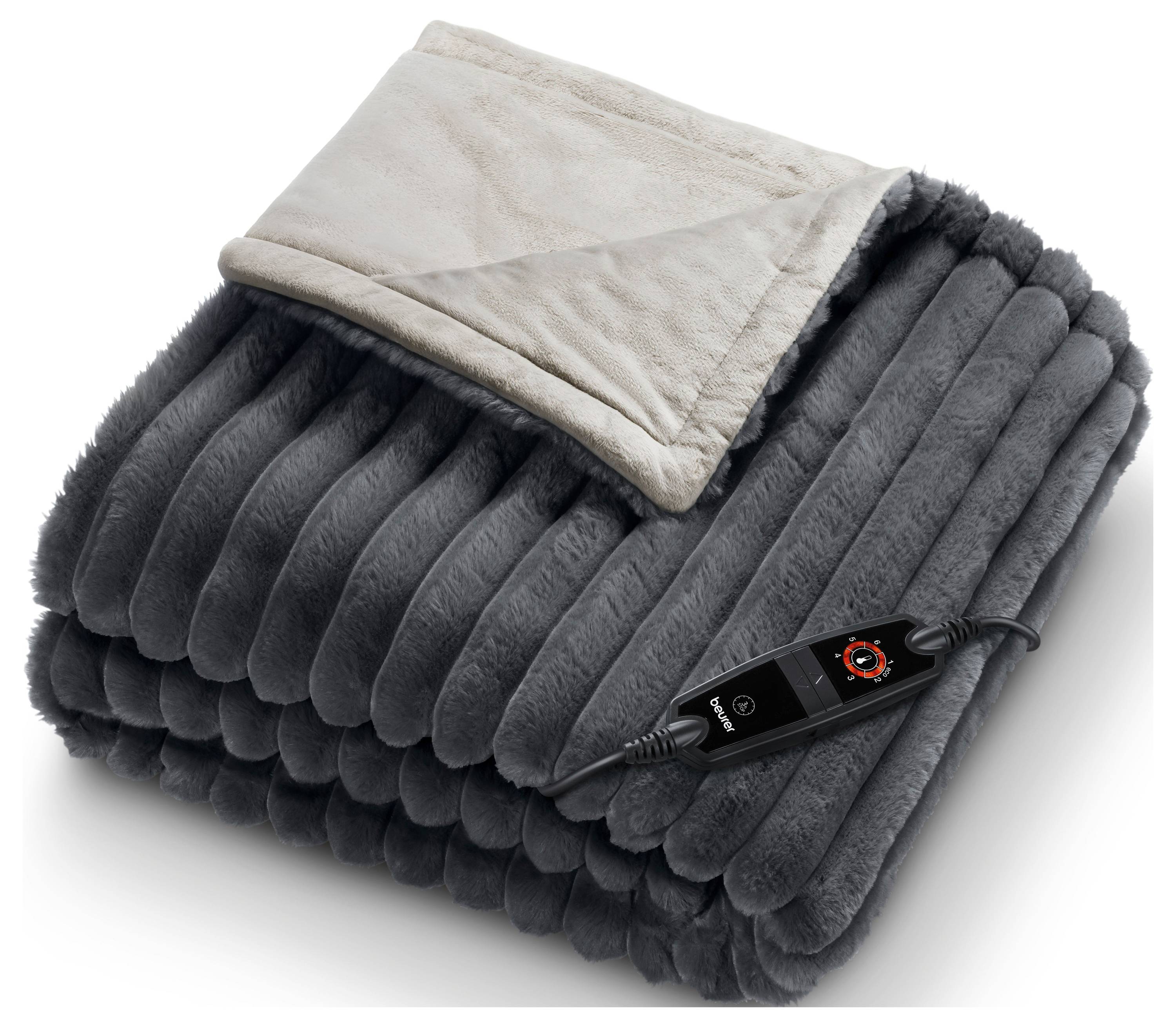 Une couverture chauffante électrique grise pliée avec une télécommande affichant les paramètres repose sur une surface. La couverture a une texture pelucheuse et nervurée.