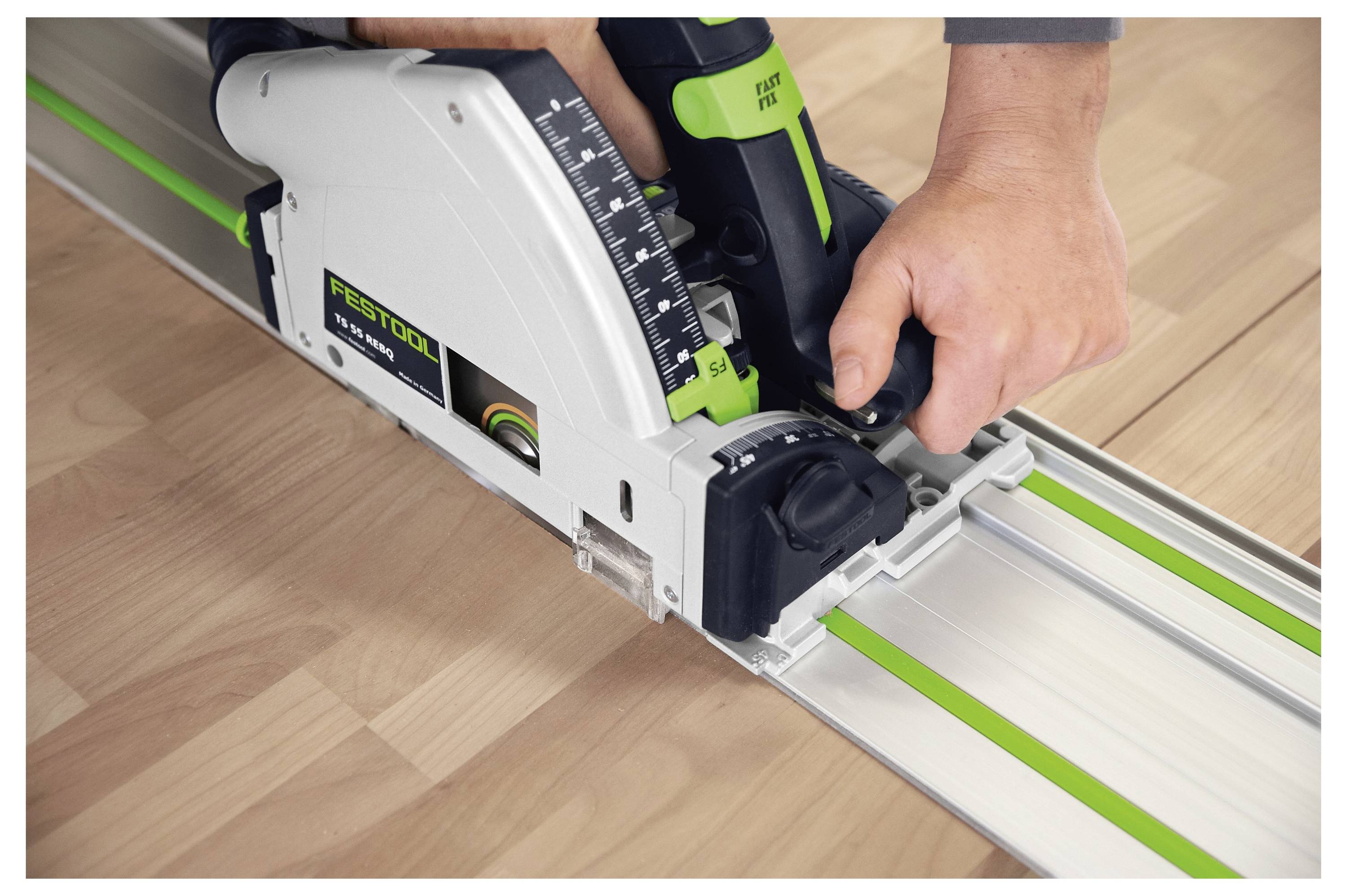 Une personne utilise une scie circulaire sur rail Festool pour couper une surface en bois le long d'un rail de guidage métallique afin d'obtenir des coupes précises et rectilignes.