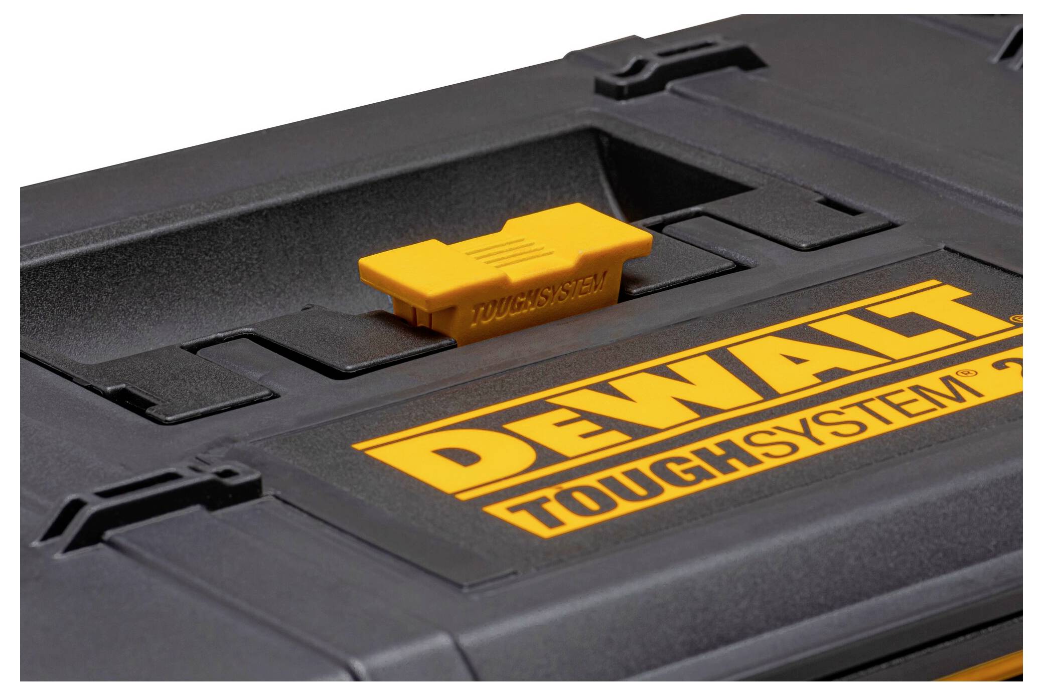 Gros plan du couvercle d'un boîtier DeWalt ToughSystem noir, présentant un loquet jaune et un logo, mettant en avant son design robuste et résistant.