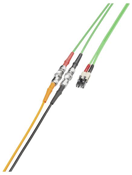 Les câbles à fibre optique avec connecteurs, y compris les câbles verts et orange, sont reliés ensemble.