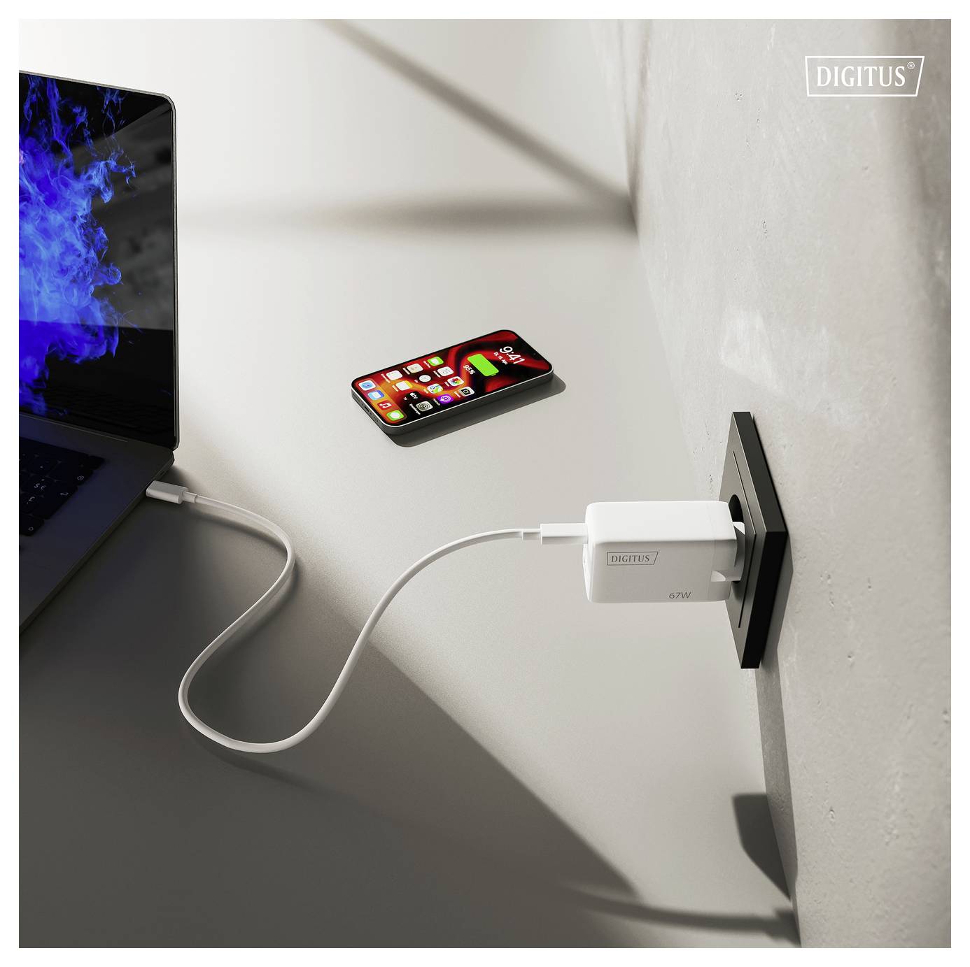 Un téléphone intelligent et un ordinateur portable connectés à une prise murale via des câbles USB dans un cadre moderne, mettant en évidence le multitâche efficace.