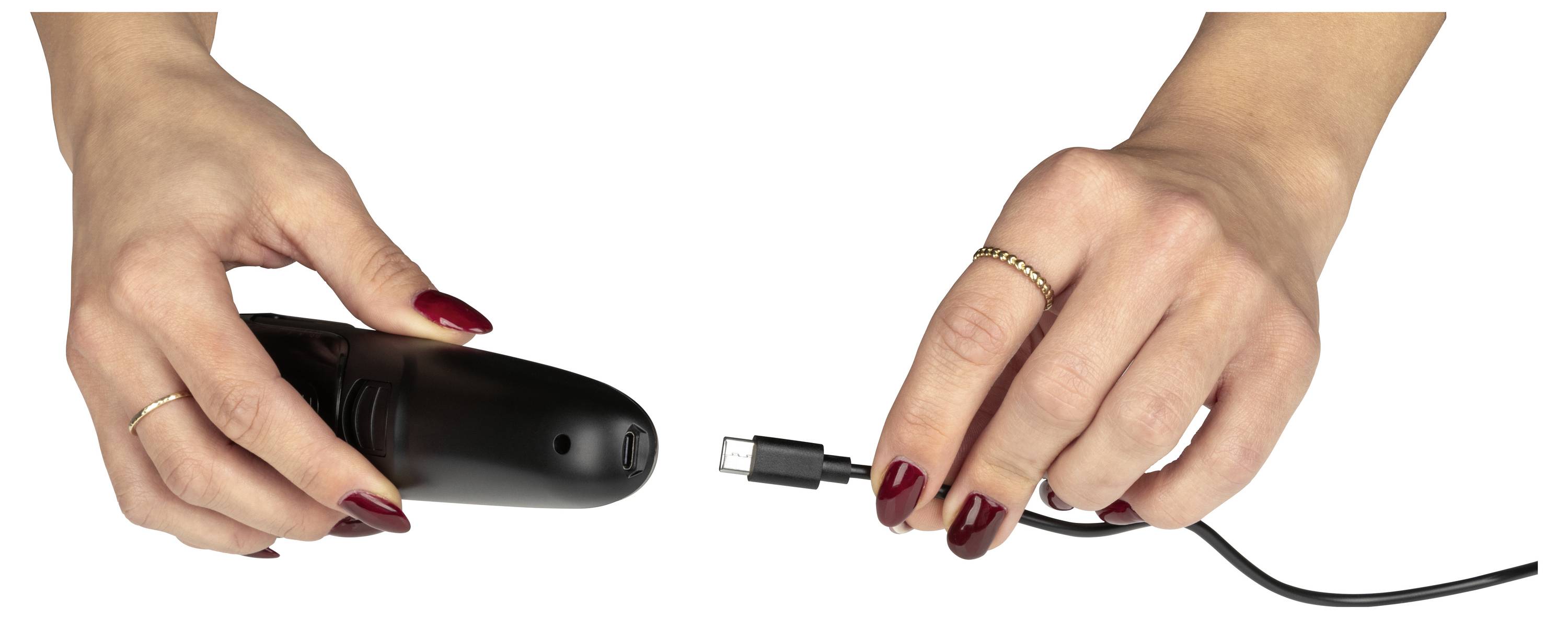 Deux mains tenant un petit appareil noir et un câble de recharge, se préparant à les connecter.
