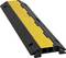 Un protecteur de câble noir et jaune avec une surface texturée conçu pour sécuriser les câbles et prévenir les risques de trébuchement dans les zones piétonnes.