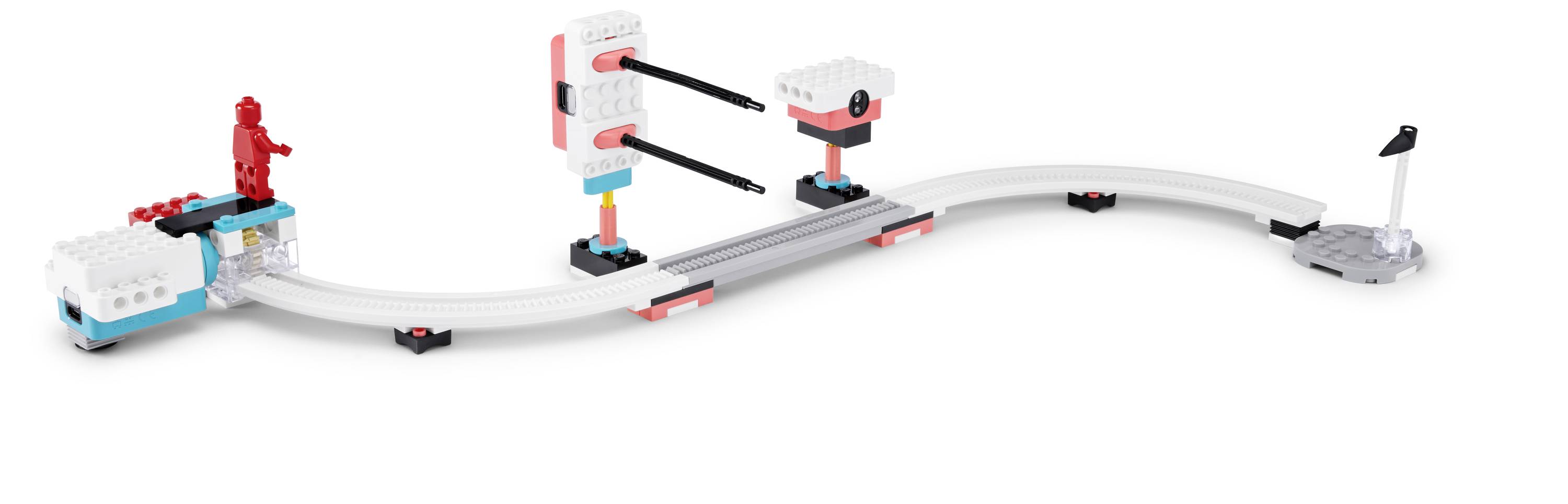 Une piste de jeu avec des sections courbes et droites comprend des blocs mobiles et des figurines, conçue pour le jeu interactif et la construction.