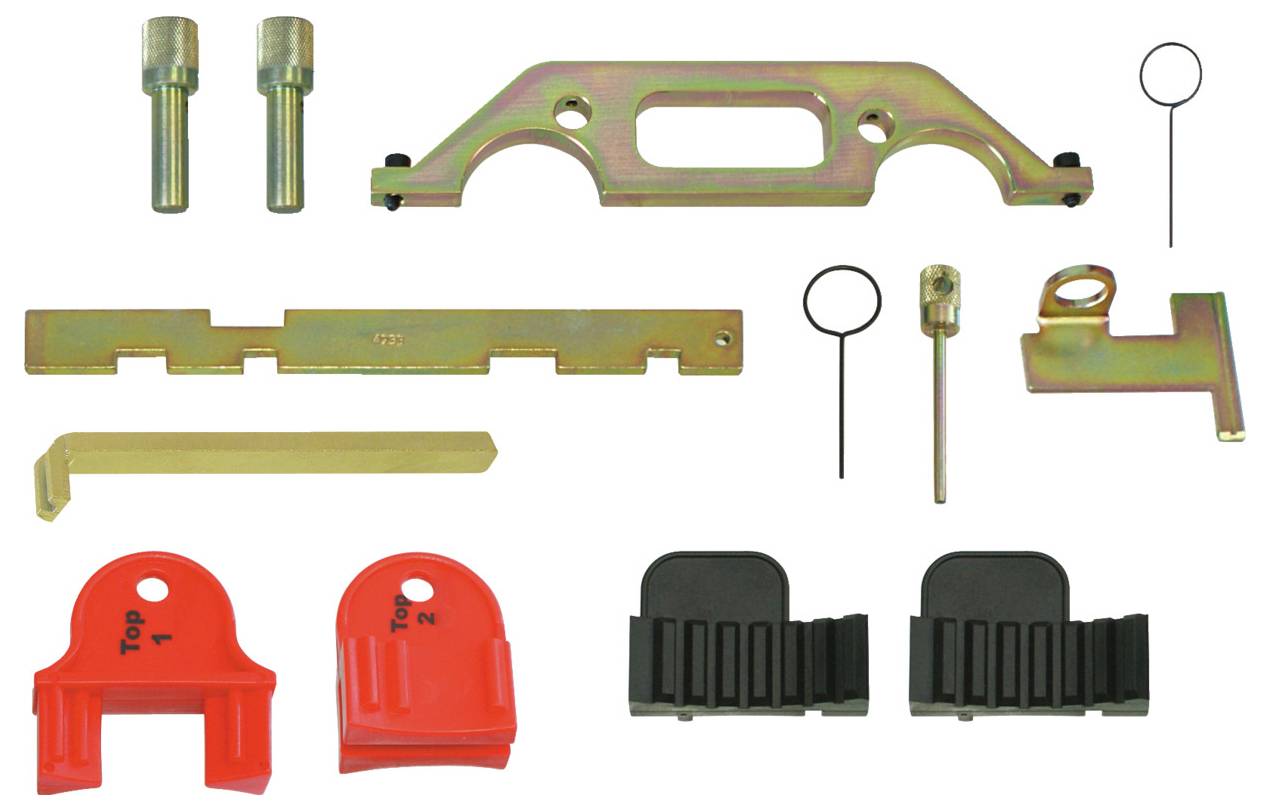 Assortiment d'outils de distribution moteur automobile en métal et en plastique, comprenant des supports d'alignement, des goupilles de verrouillage et des guides, disposés sur une surface.