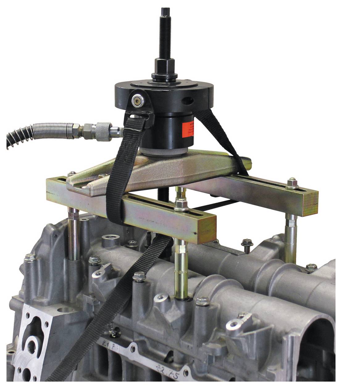 Barre de support moteur avec mécanisme de levage attaché à un bloc moteur, présentant l'équipement d'entretien des véhicules.