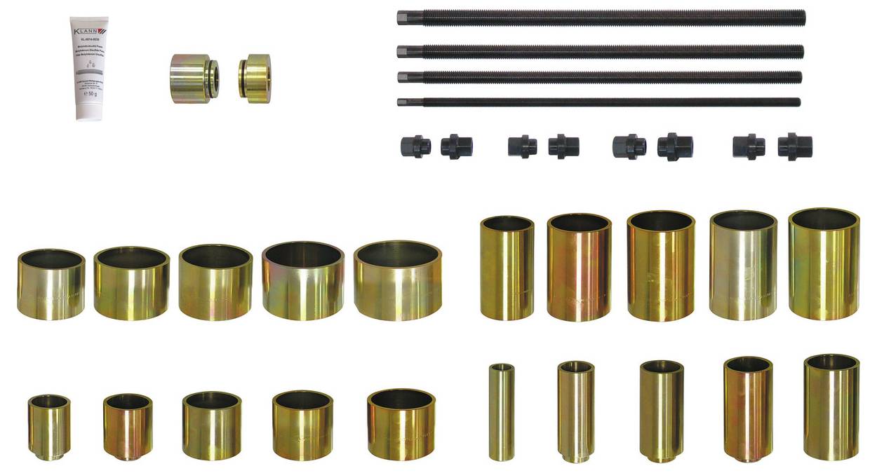 Une collection d'outils cylindriques métalliques et de tiges de différentes tailles, accompagnée d'un petit tube, probablement une partie d'un kit mécanique.