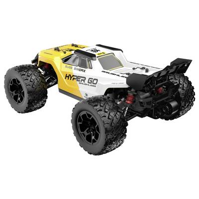 Un camion de course tout-terrain télécommandé jaune et blanc avec des pneus cloutés surdimensionnés sur fond blanc.