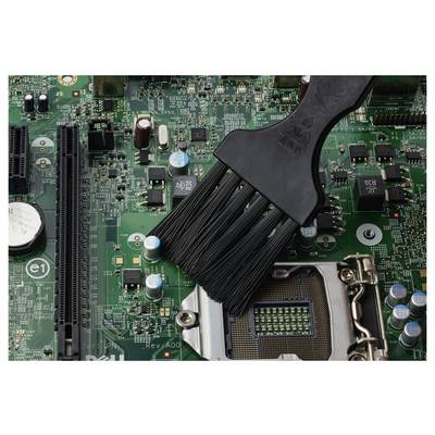 Un pinceau noir nettoyant la poussière sur une carte mère d'ordinateur près du socket CPU et des composants.