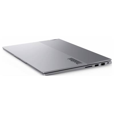 Ordinateur portable Lenovo argenté montré fermé selon un angle, avec des ports visibles et le logo Lenovo sur le couvercle.